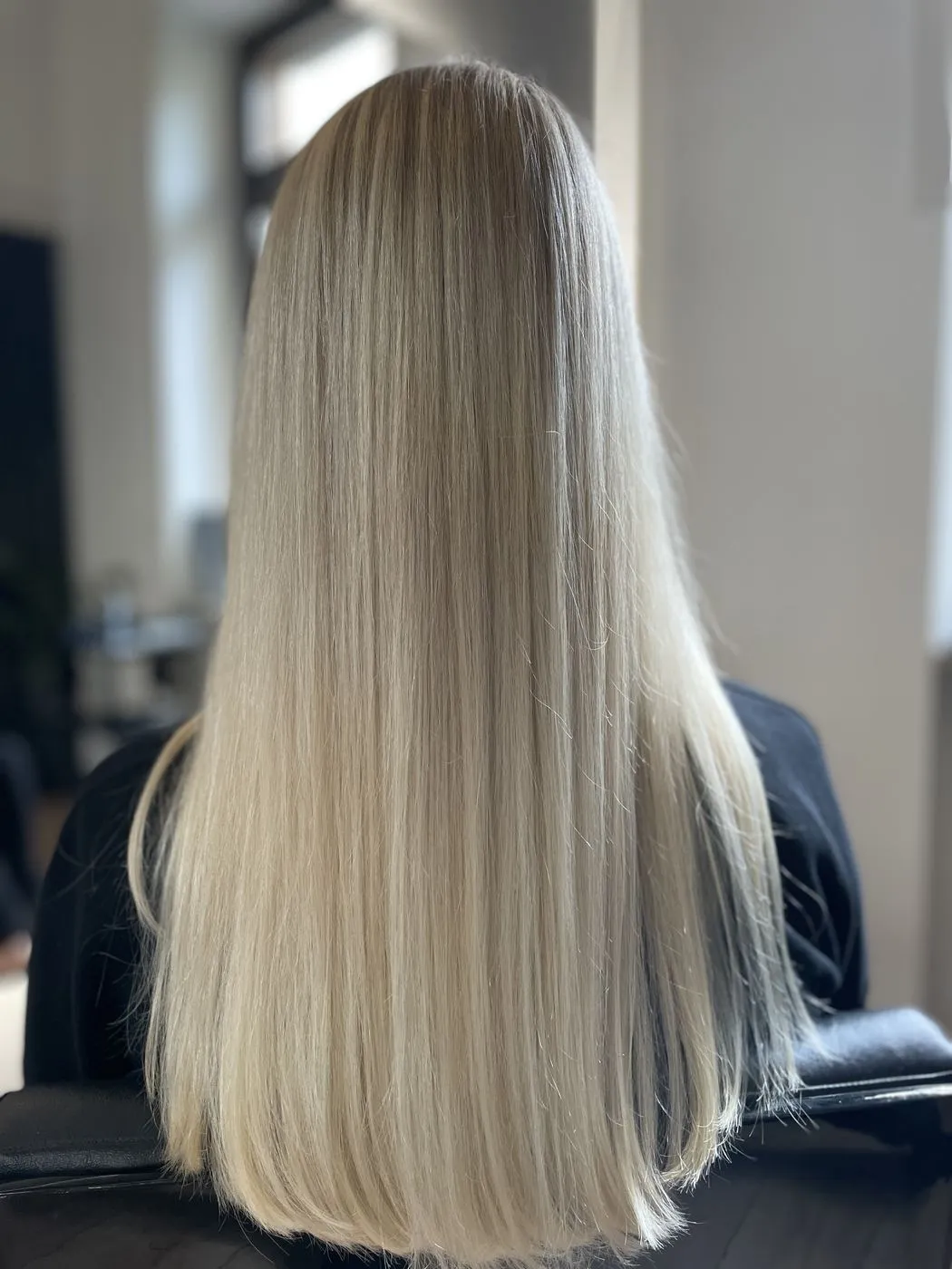 Langes, glattes, kühles Blond von hinten im Salon