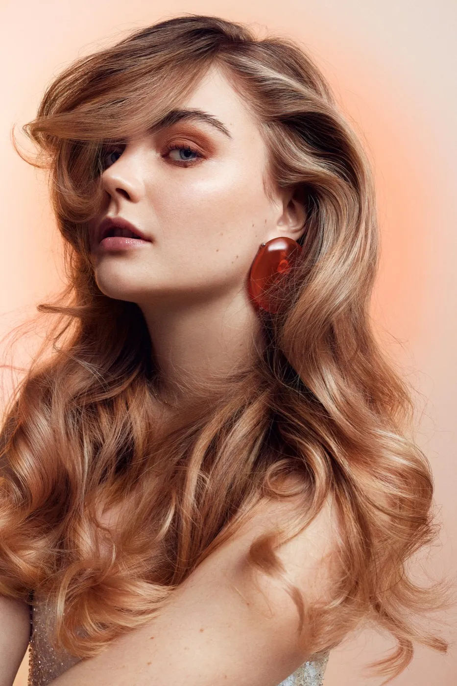 Look aus Kollektion 5: Model mit langen, weich gewellten Haaren in warmem Honigblond