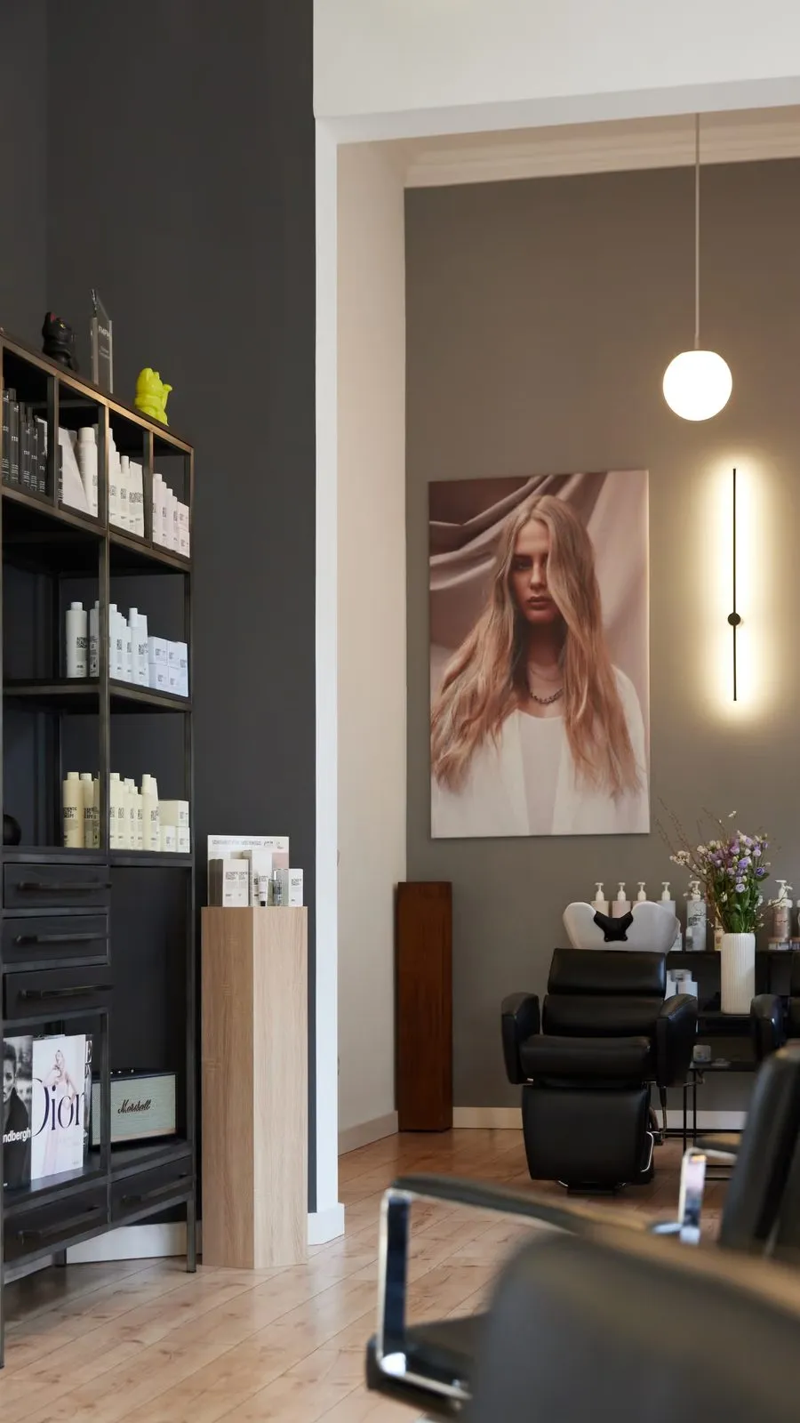 Foto aus dem Innenbereich des Salons mit Kampagnenbild an der Wand
