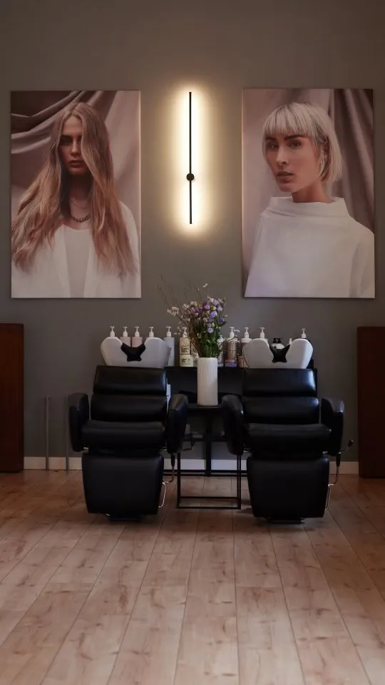 Waschbereich im Salon mit Kampagnenbildern an der Wand